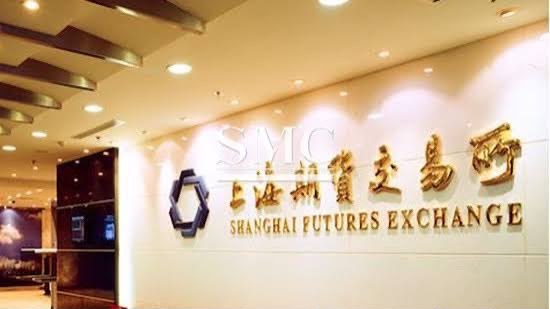 An illuminated Shanghai Futures Exchange sign in gold lettering above a reception desk in a marble lobby.
